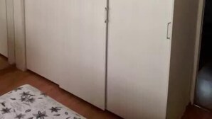 Une pièce avec une grande armoire blanche, un tapis à motifs floraux et un mur uni.