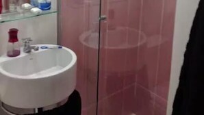 Une salle de bain avec une douche à parois de verre, un lavabo blanc et un miroir.
