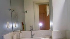 Un baño con un lavamanos blanco, un espejo y un inodoro.