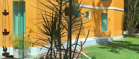 A yellow building with a sign that reads "HOTEL" and a flower decoration.