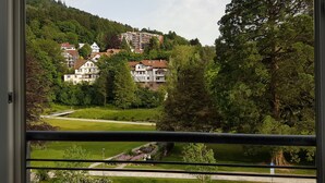 Une vue d’un quartier résidentiel avec des maisons, un chemin et un grand arbre.