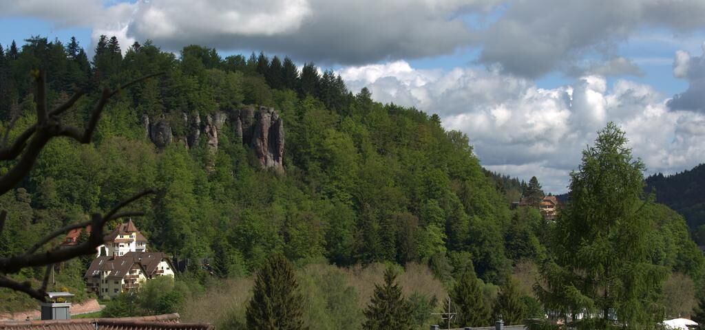 A mountainous landscape with a building surrounded by trees.