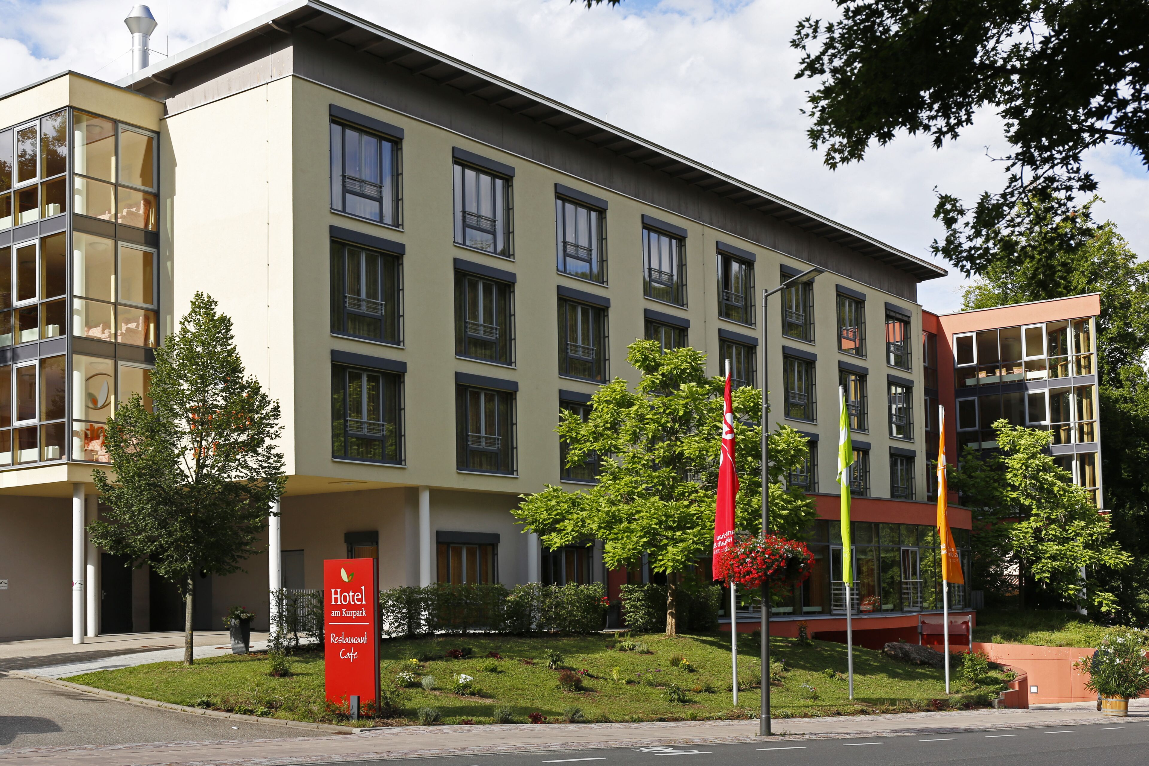 A modern hotel building with a sign indicating it is a "Hotel am Kurg".