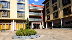 Un hôtel à la façade moderne, doté de nombreux balcons, et offrant une vue sur un ciel dégagé.