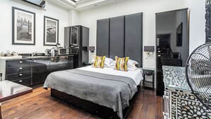 Un dormitorio moderno con una cama grande, un armario empotrado, un escritorio y una mesa de comedor.