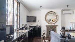 Una cocina moderna con una isla grande, electrodomésticos integrados y un televisor de pantalla plana.