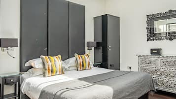 Een moderne slaapkamer met dakraam, een groot bed, een kledingkast en een console tafel met een patroon.