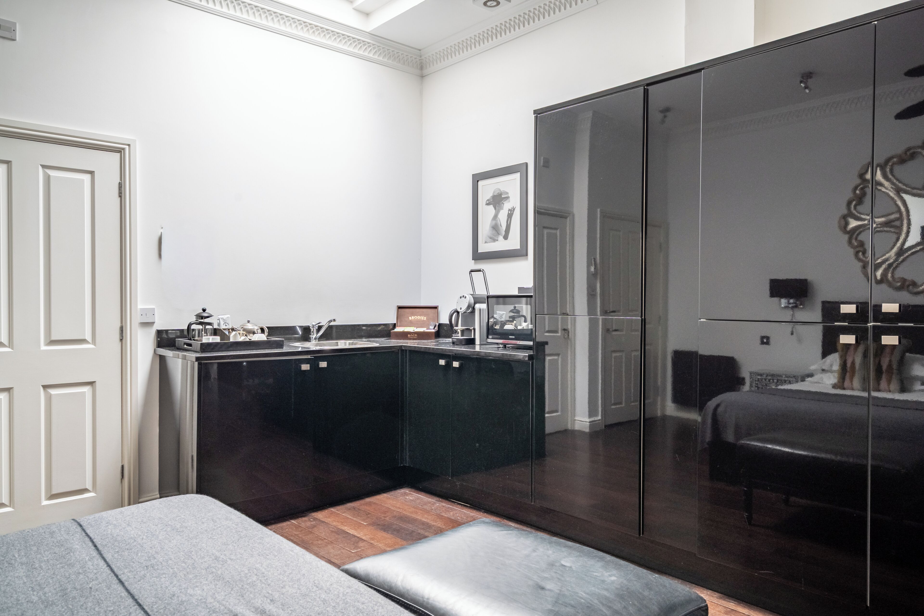 Een moderne keuken met donkere kastjes, een aanrecht en een zithoek met een bank.