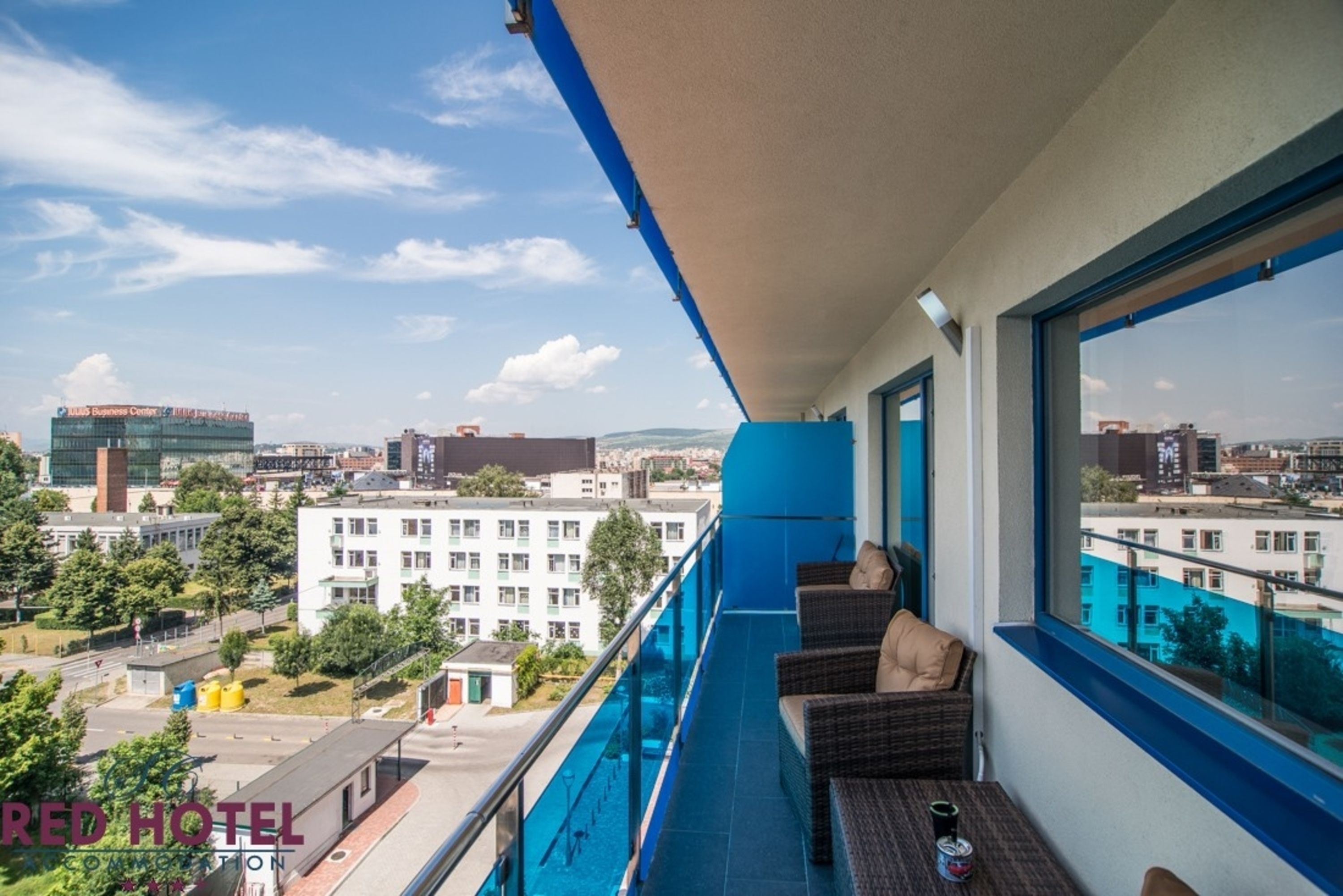 A balcony with a view of a cityscape, including a business center and residential buildings.
