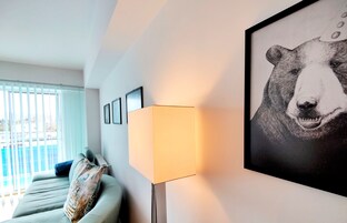 Una habitación con un sofá, una lámpara y un cuadro en la pared.