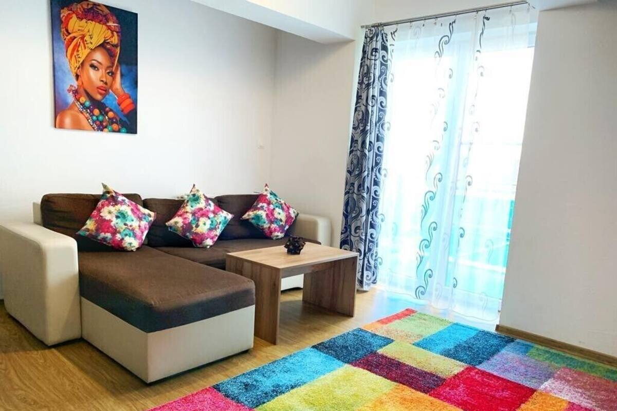 Una sala moderna con sofá, mesa de centro y alfombra colorida.