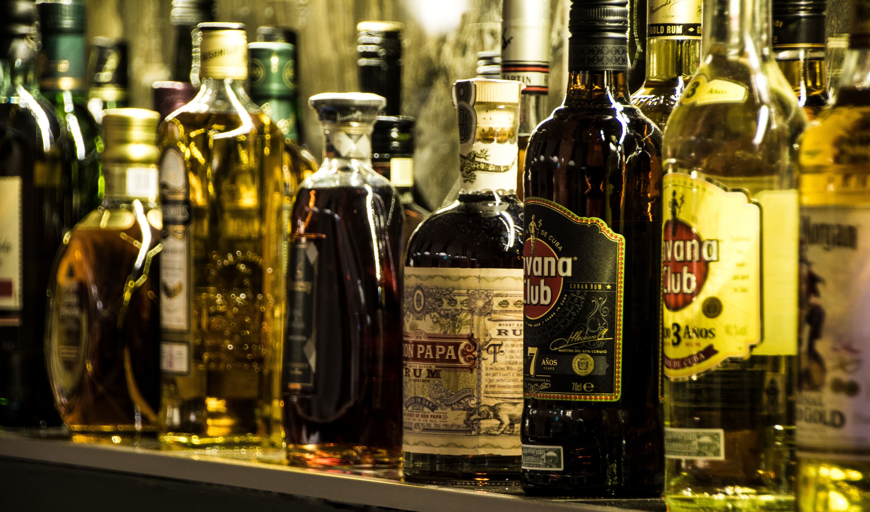 Variedad de botellas de licor en una estantería.