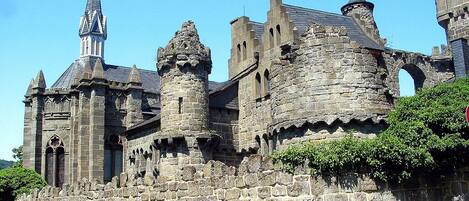 A historic stone castle with multiple towers and a prominent spire.