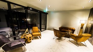 A modern living room with a glass partition, leather sofas, and a marble floor. - Mountainpark Kassel (Kassel)