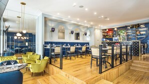Interno di un ristorante con pavimento in legno, sedute blu e una zona bar.