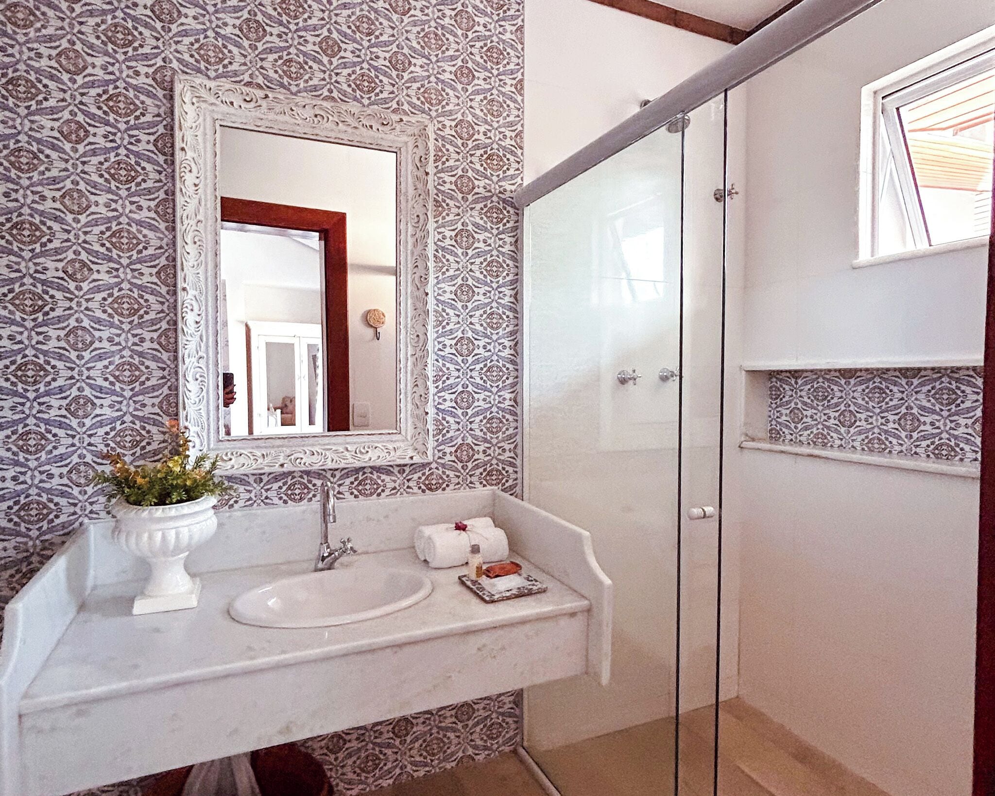 A bathroom with a white sink, a mirror, and a shower.