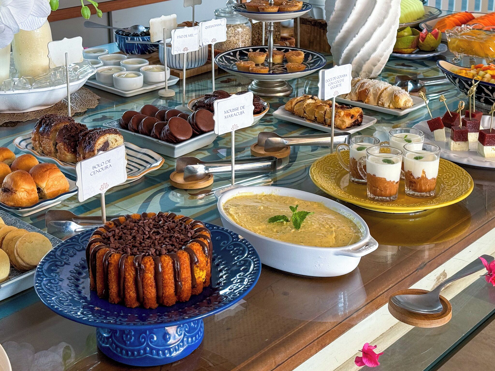 A buffet with various food items including pastries, desserts, and beverages.