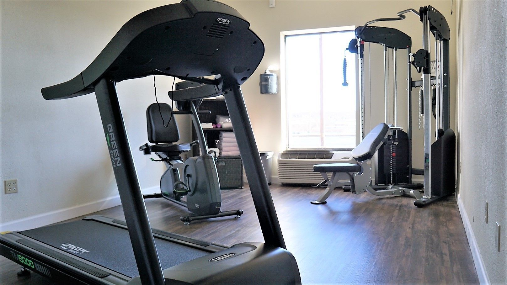 A gym with a treadmill, stationary bike, and weight machines.