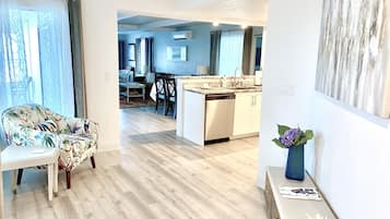 Um apartamento moderno com sala de estar, sala de jantar e cozinha.