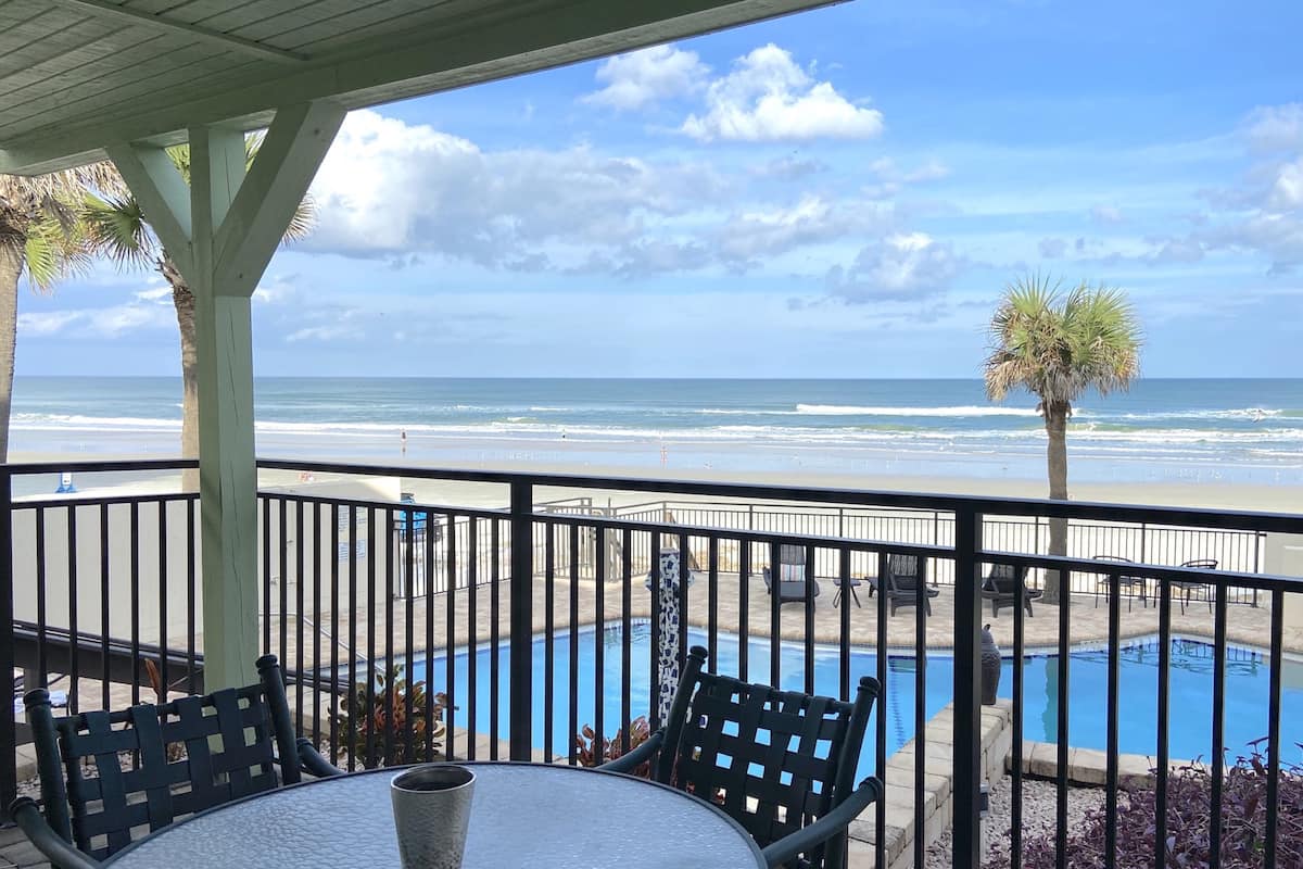 A poolside area with a view of the beach and ocean.
