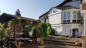 A patio area with a pergola, seating, and potted plants. - H41 Inn Freiburg (Gundelfingen)