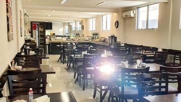 A spacious dining area with multiple tables and chairs, a buffet setup, and a clean, well-lit environment.