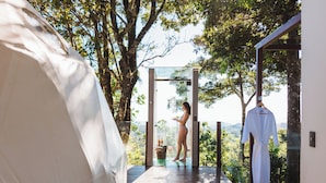 A wooden deck with a glass balustrade overlooking a lush landscape. - Chira Glamping Resort Monteverde (Monteverde)