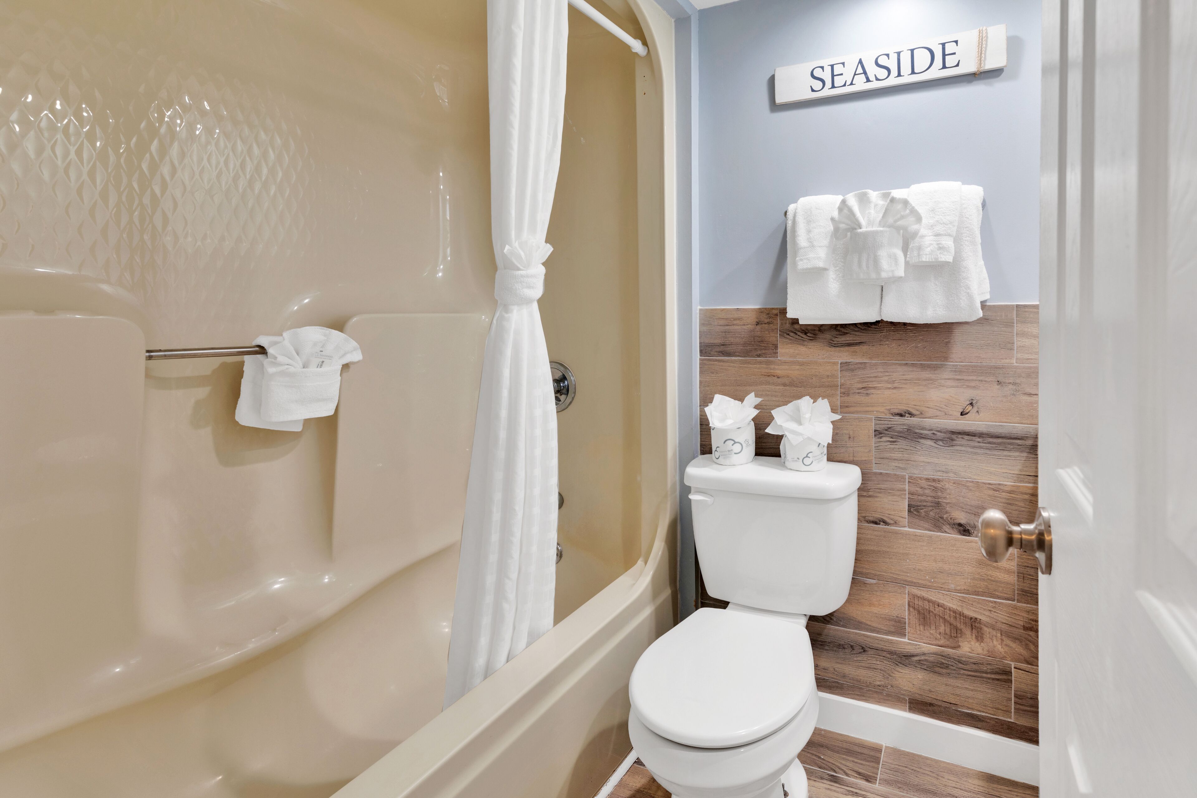 A bathroom with a bathtub, toilet, and a shower curtain.