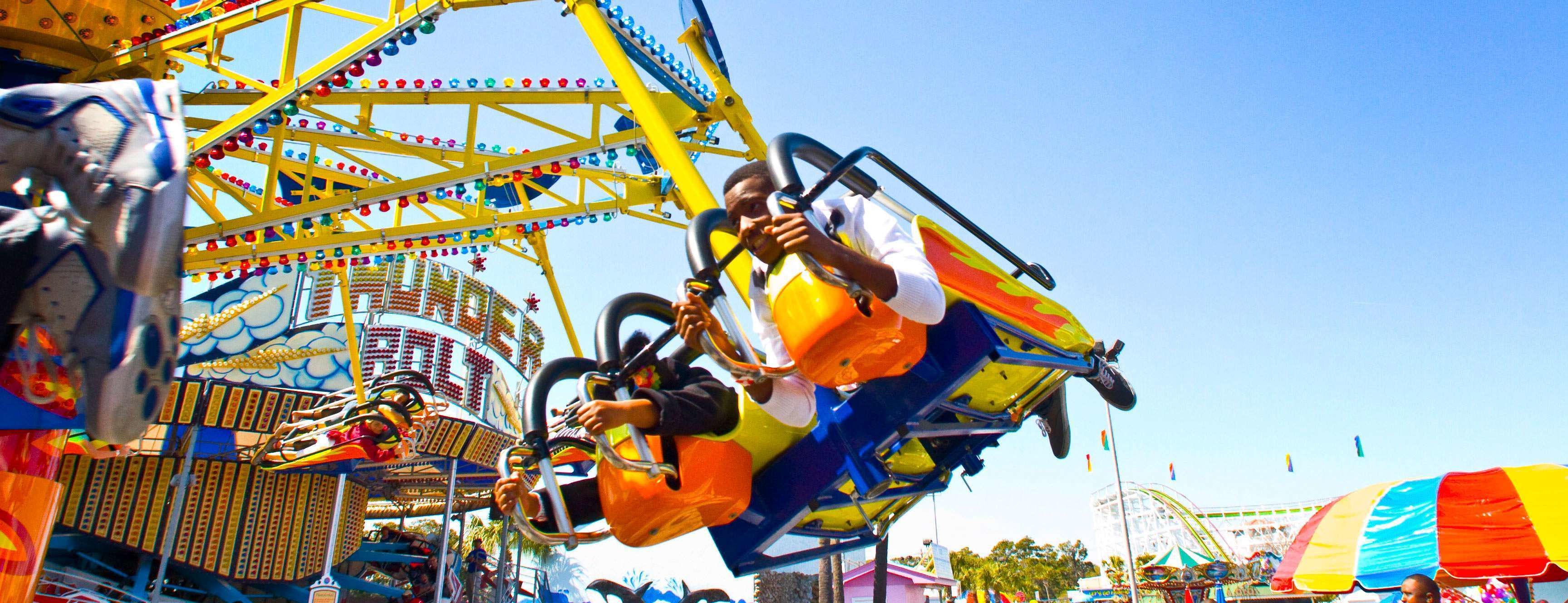 A ride at an amusement park with a colorful structure and a clear blue sky.