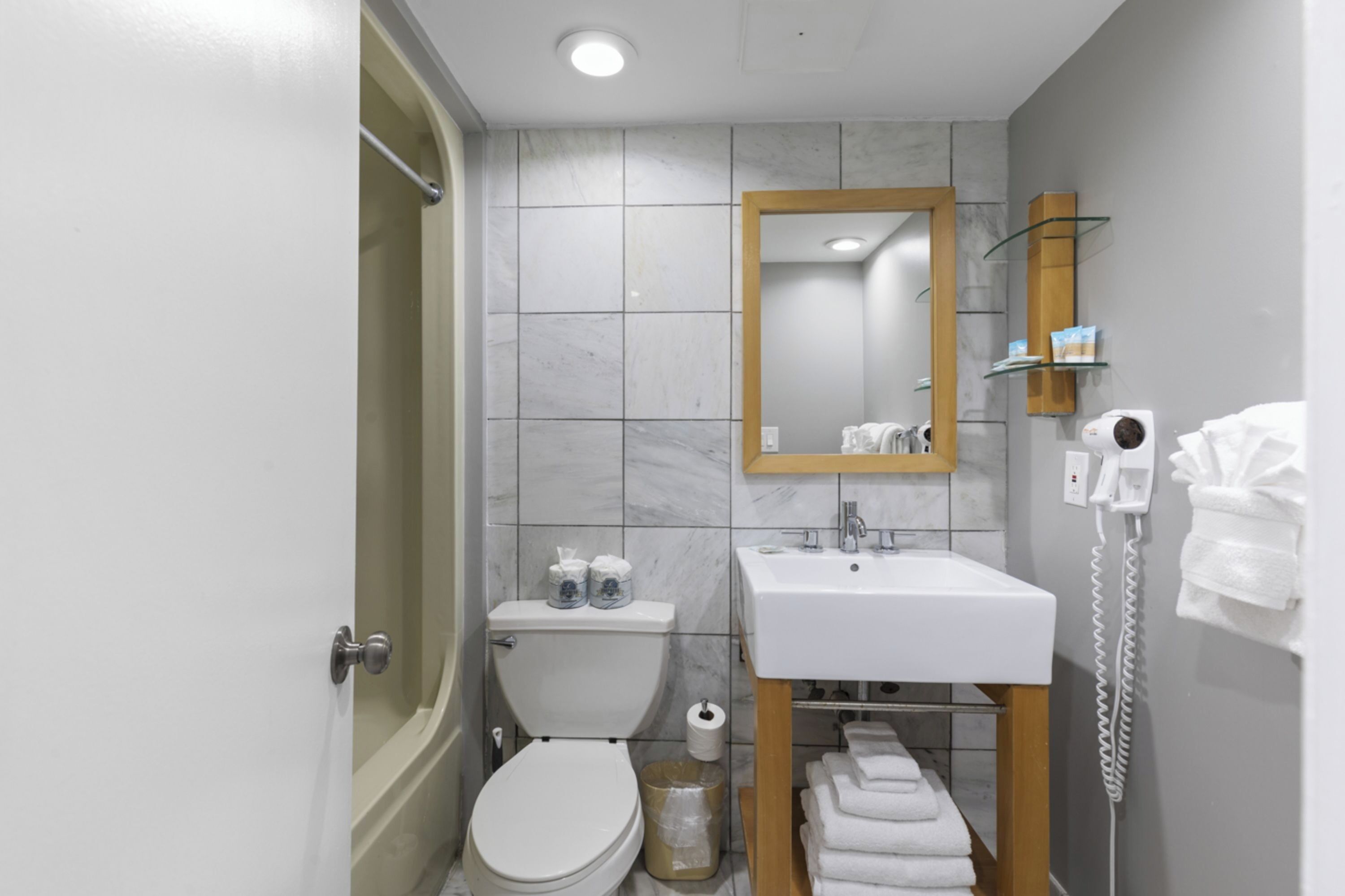 Ein modernes Badezimmer mit Toilette, Waschbecken, Spiegel und Dusche.