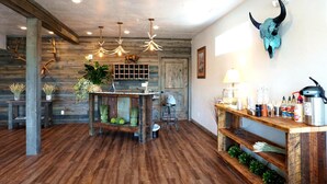 Un intérieur rustique avec un bar en bois, des luminaires suspendus et une décoration murale représentant un crâne.