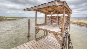 Una terrazza panoramica in legno con un cartello ‘NO TRESSPASSER’, affacciata su una distesa d'acqua.