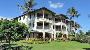 A large, two-story house with multiple balconies, surrounded by lush greenery and palm trees. - Best Deal!  Boogie Boards, Snorkel Gear, Baby Gear, Golf!  Its all in the deal! (Waikoloa)