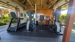 A covered gym area with treadmills, elliptical machines, and a ceiling fan. - Best Deal!  Boogie Boards, Snorkel Gear, Baby Gear, Golf!  Its all in the deal! (Waikoloa)
