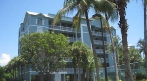 Um hotel com várias andares, varandas e uma entrada central.