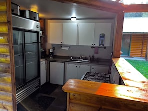 Uma cozinha compacta com geladeira, fogão e armários.