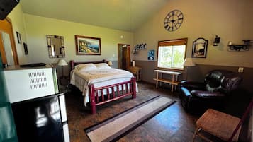 A bedroom with a bed, a desk, a chair, a clock, and a window.