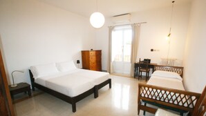 A bedroom with two beds, a wooden dresser, a desk, and a chair. - Rome Apartment Rentals Colosseum View - Roof Terrace with 2BR/2BATH Wi-Fi (Roma)