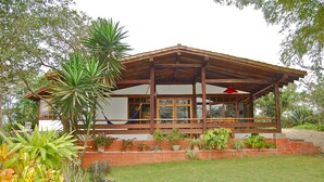 Ein Haus mit einer Holzbalkonveranda, Backstufen und verschiedenen Blumentöpfen.