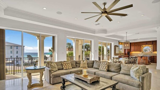 A spacious living room with a large sectional sofa, a coffee table, and a ceiling fan. - Over the Top | 7 Bedroom! | Clubhouse Amenities! Pickleball, Gym & Hot Tub! | Pet-Friendly Escape in Destin | Private Pool | Gulf Views! Wedding Friendly! (Destin)