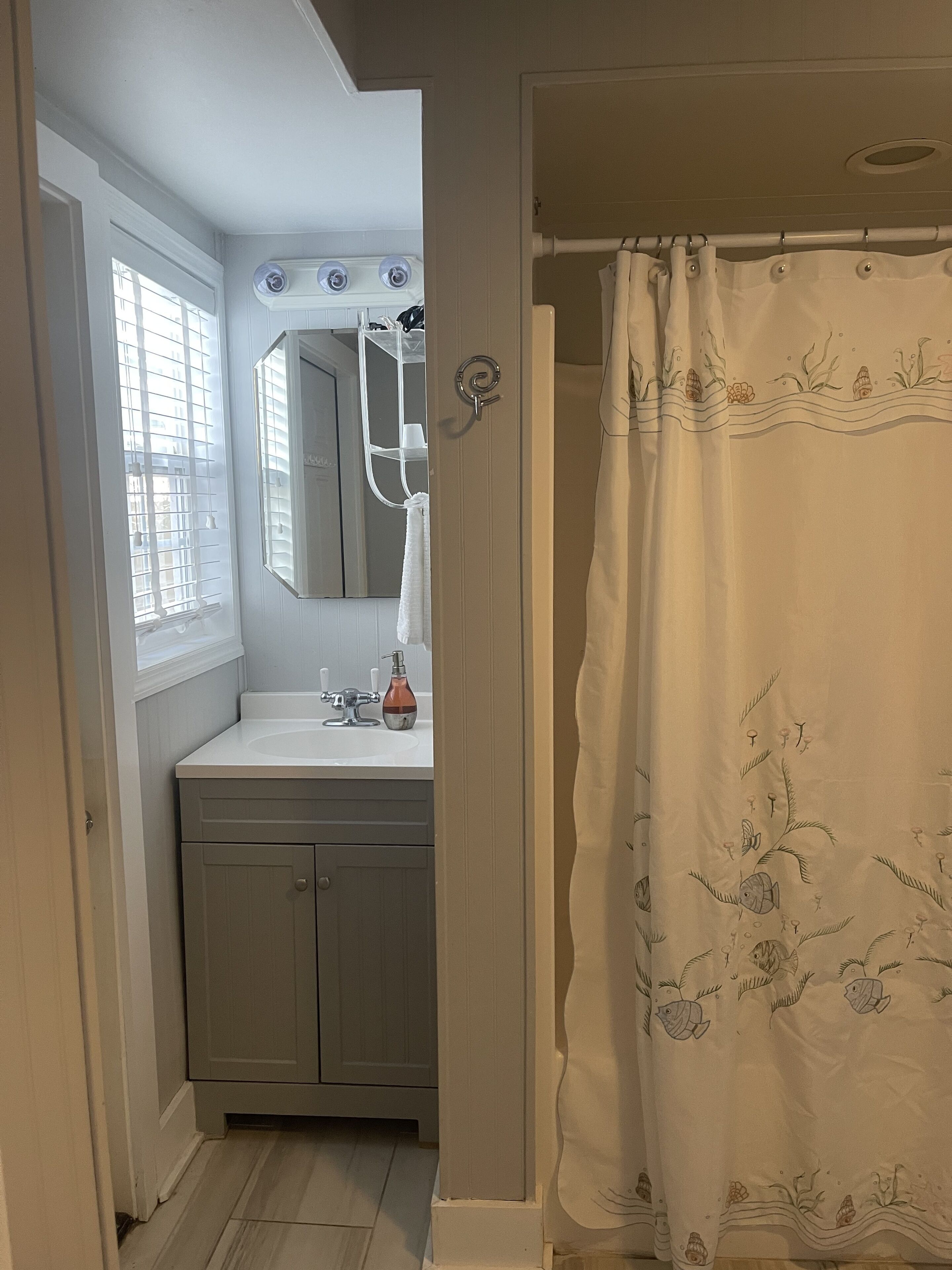 A bathroom with a white sink, mirror, and towel rack.