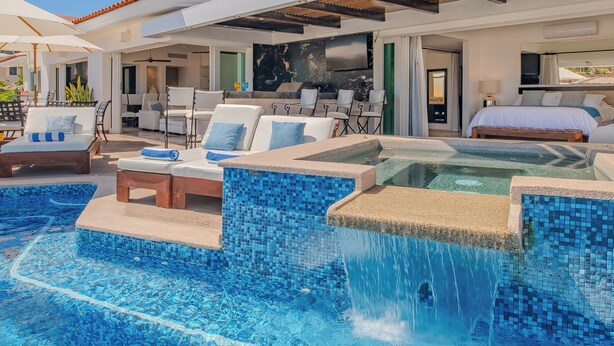Un área de piscina moderna al aire libre con un jacuzzi, sillas de descanso y un comedor.