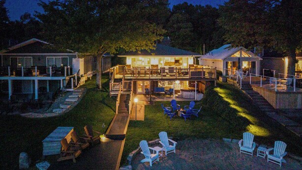 Una grande casa con un'ampia area patio esterna, una piscina e diversi angoli relax.