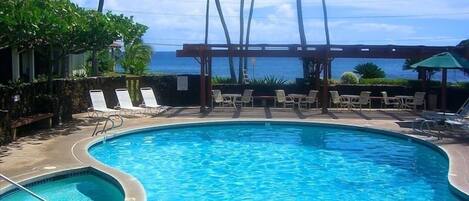 Une piscine avec des chaises longues et vue sur l’océan.