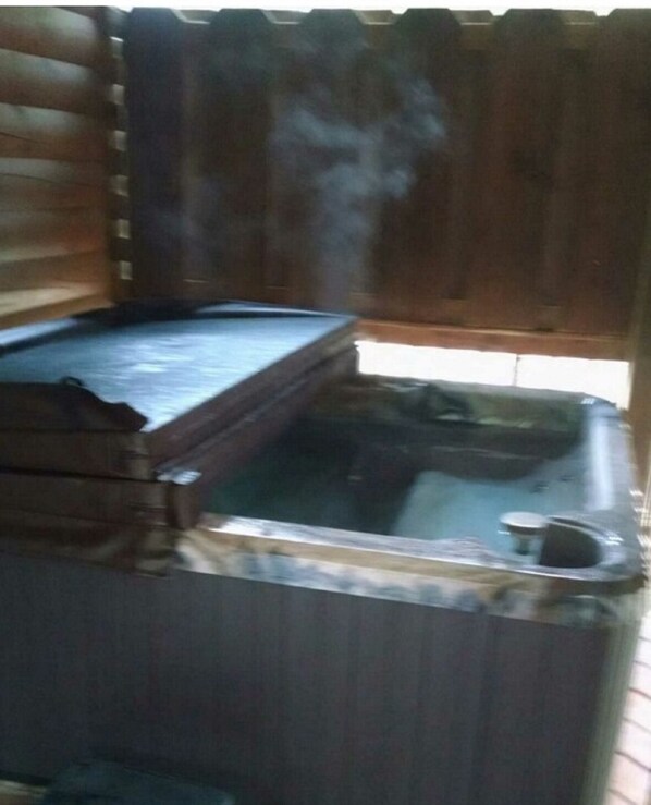 Una sauna con banca de madera y salida de vapor.