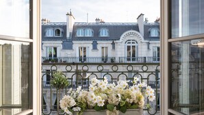 A balcony with a wrought iron railing and a planter with white flowers. - One-of-a-Kind 3-bedroom OMG Eiffel Views & Wraparound Terrace (Paris)