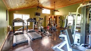 Een fitnessruimte met loopbanden, hometrainers en krachtapparaten.