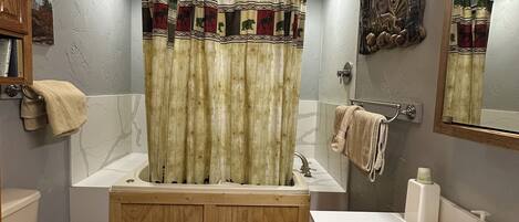 Een badkamer met een bad, toilet en wastafel.