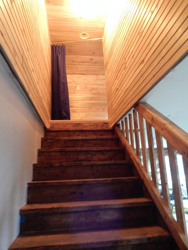 Eine Holztreppe mit Geländer und Decke aus Holz.