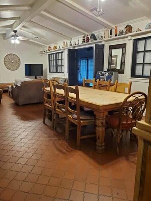 Un comedor con una mesa y sillas de madera, un sofá y una televisión.